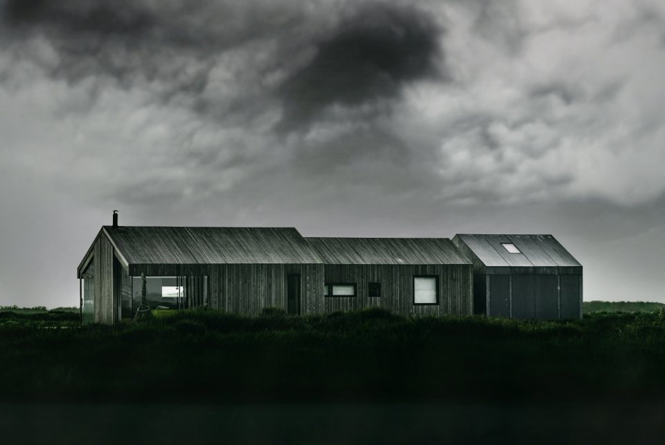 Black barn house under a storm sky
