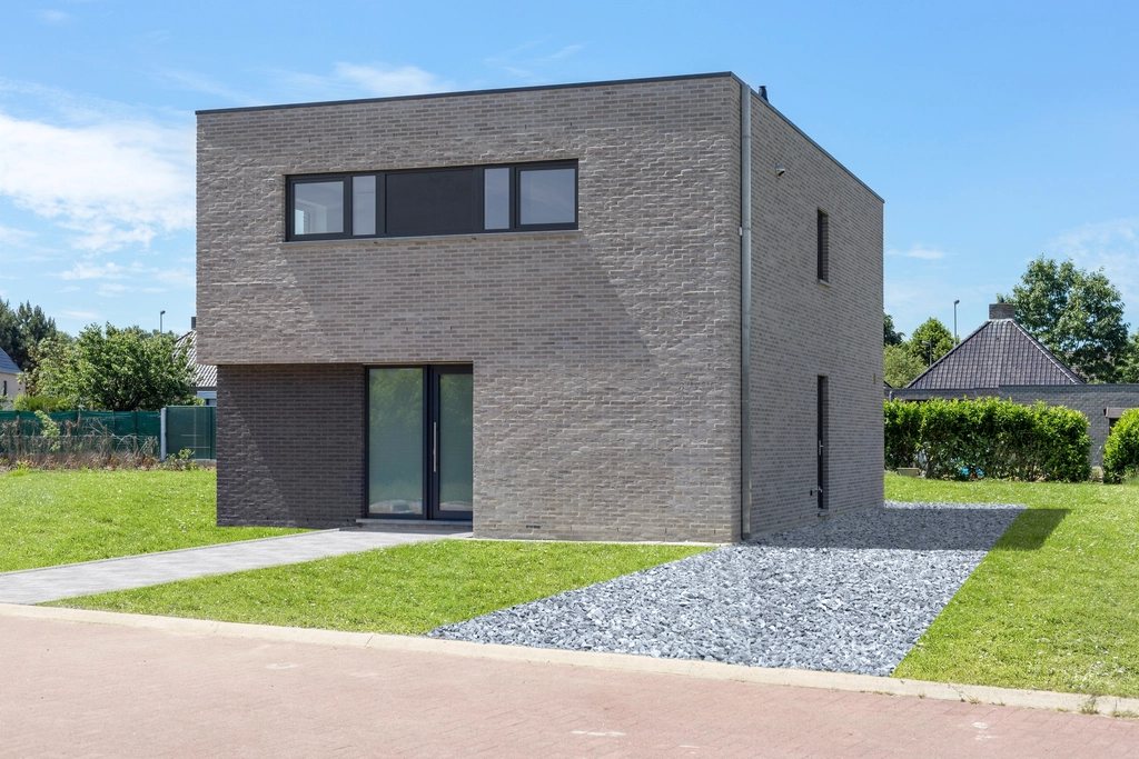 Brick cube house with a gravel path