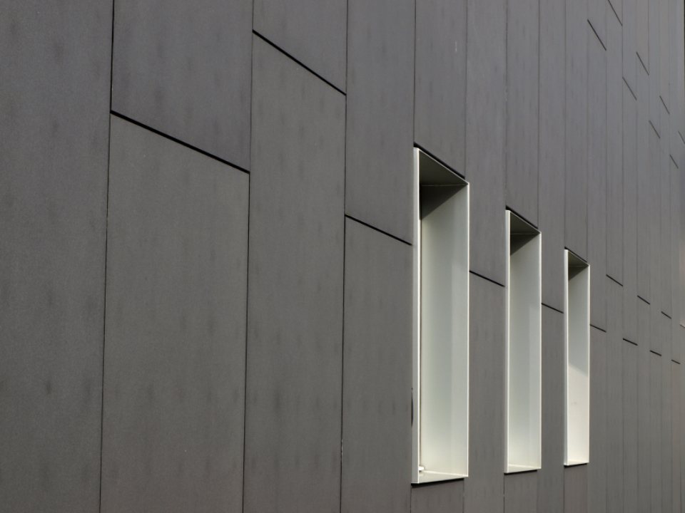 Deep window slots in a dark facade