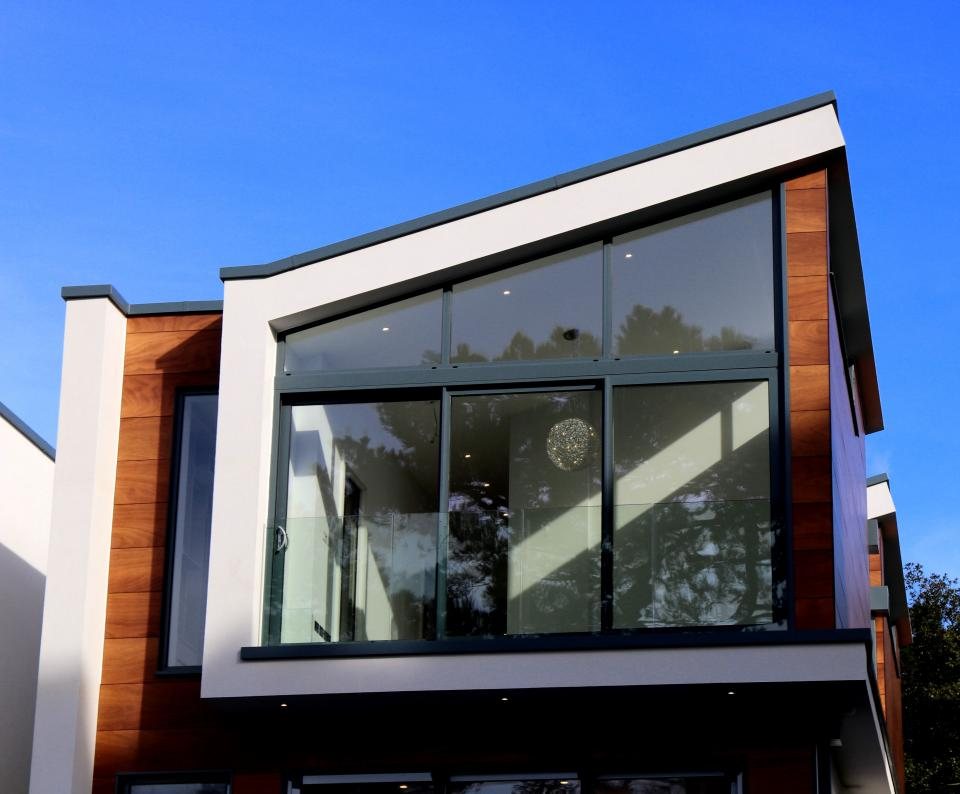 Glazed gable framed in white render and timber