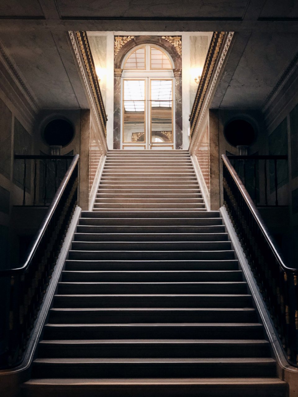Stone stair hall with a lit doorway