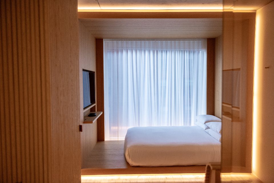 Timber-lined bedroom with sheer curtains