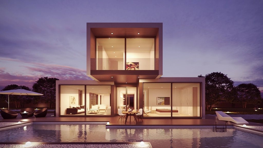 Cubic villa lit at dusk above a reflecting pool