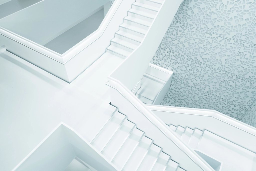 White stairs folding around a light well